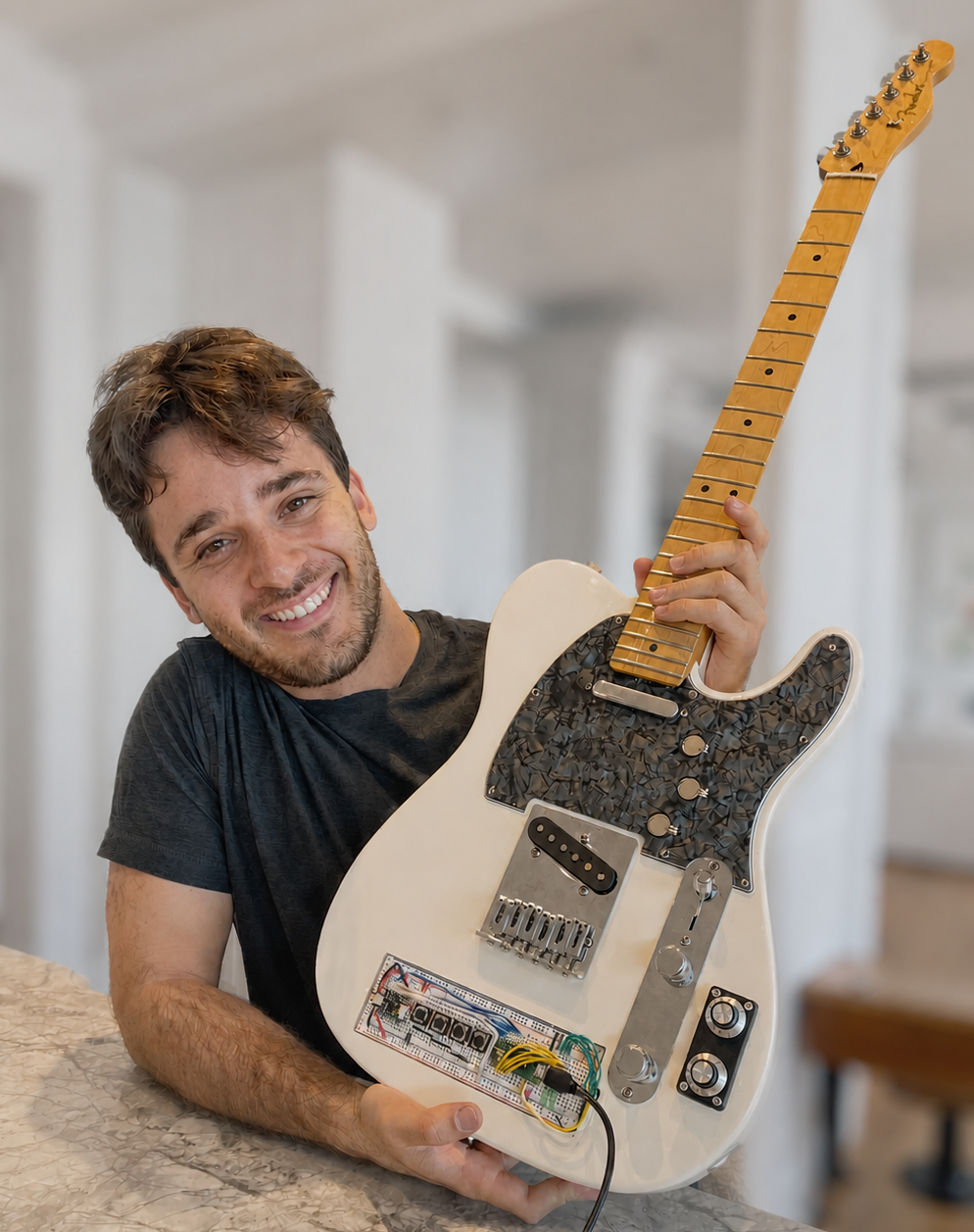 Jamie Malz holding a white Fender Telecaster modified with a breadboard microcontroller circuit